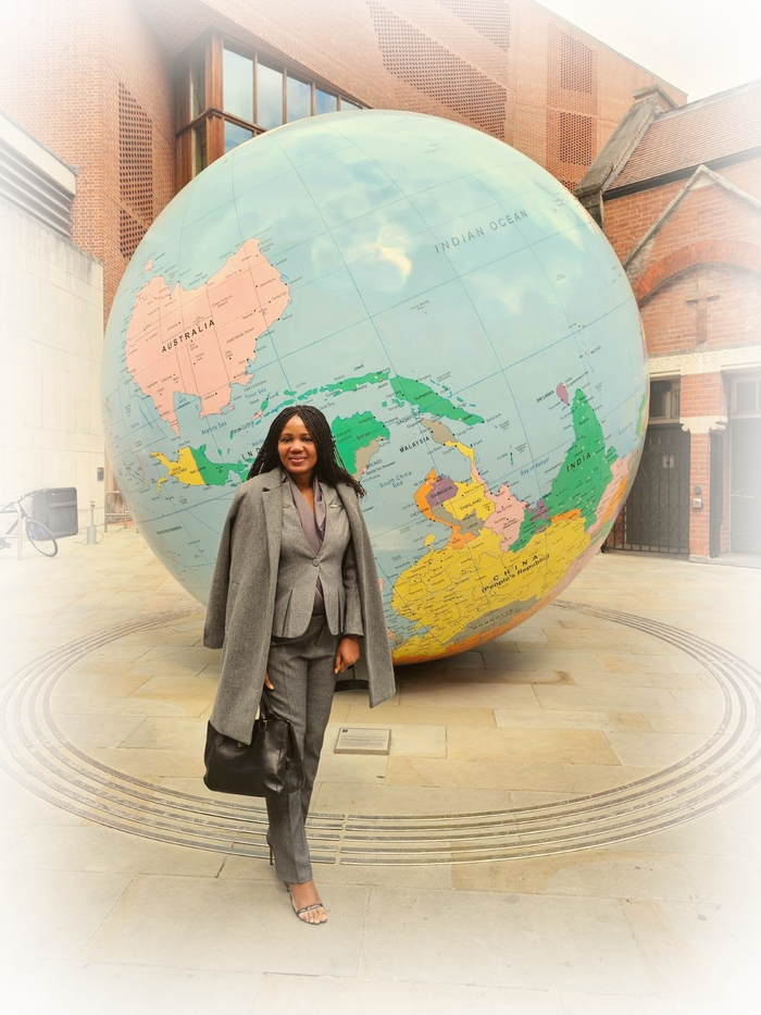 Kadine Reynolds standing before a large globe sculpture