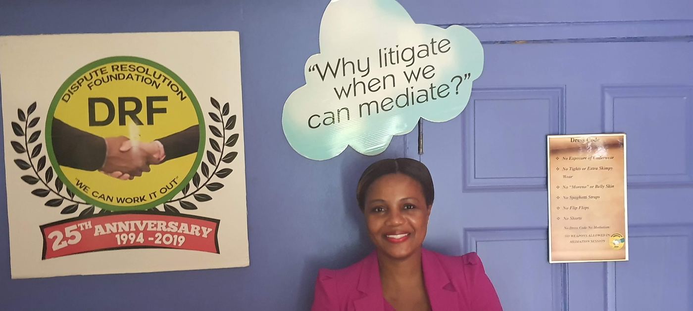 Kadine Reynolds beside the Dispute Resolution Foundation signage